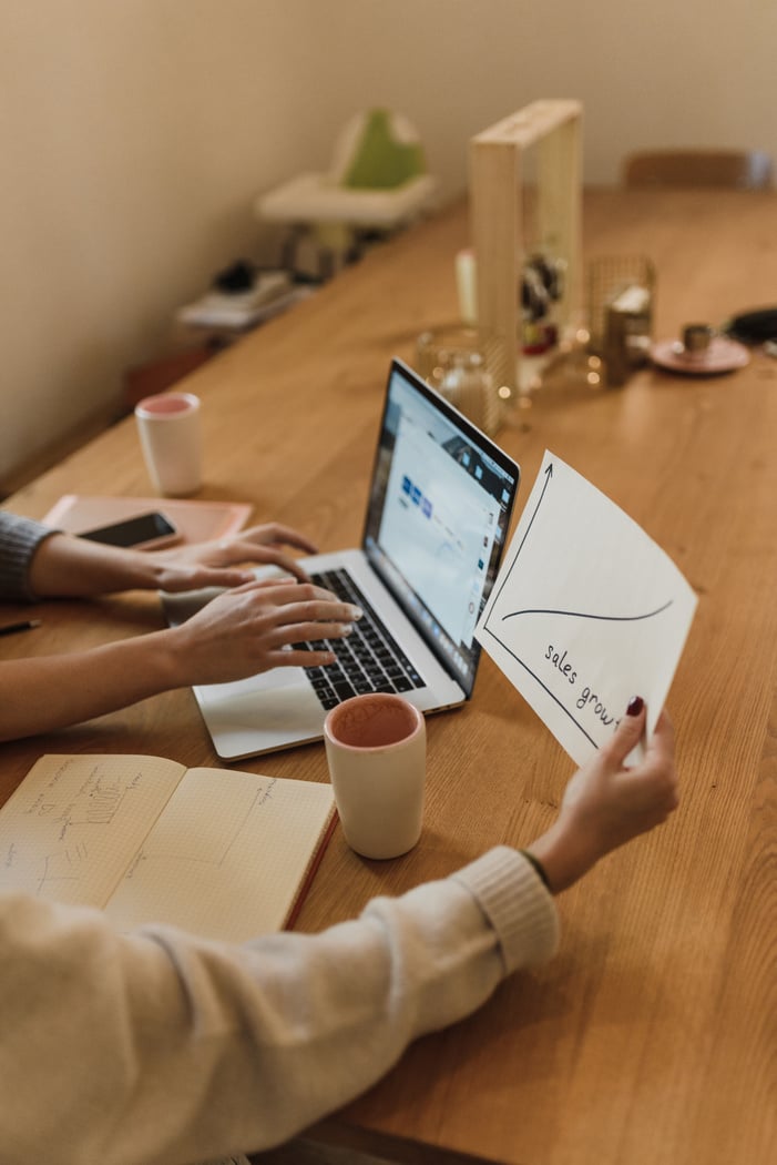 Person in White Long Sleeve Shirt Using Macbook Air